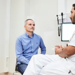 En lege som snakker med en pasient