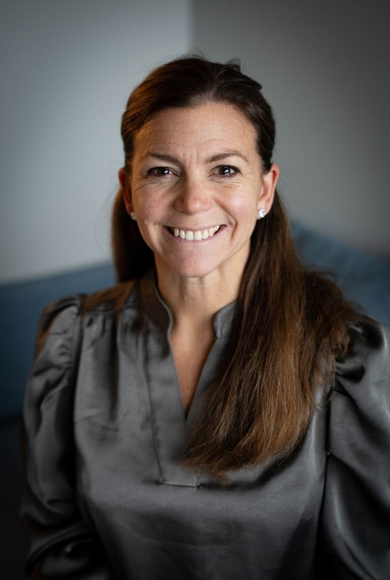 En person med langt hår som smiler