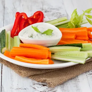 En tallerken med kuttede grønnsaker og dip