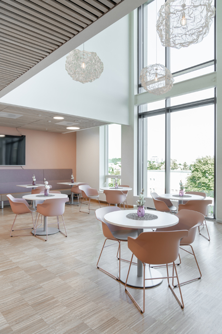 Et rom med bord og stoler og store vinduer