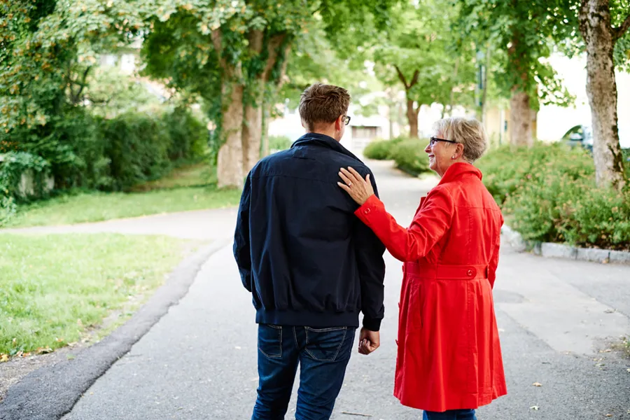 A man and woman walking on a sidewalk