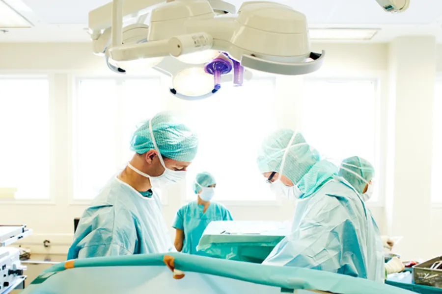 En gruppe kirurger og operasjonssykepleiere i en operasjonssal