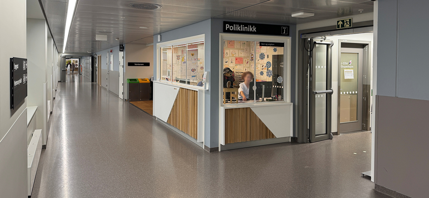 En person som sitter ved en disk i et rom med flere dører