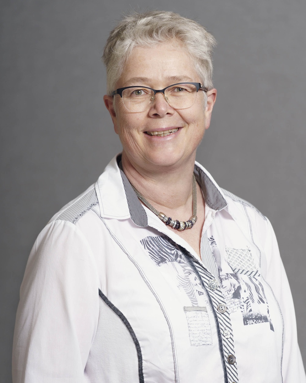 En smilende kvinne med briller