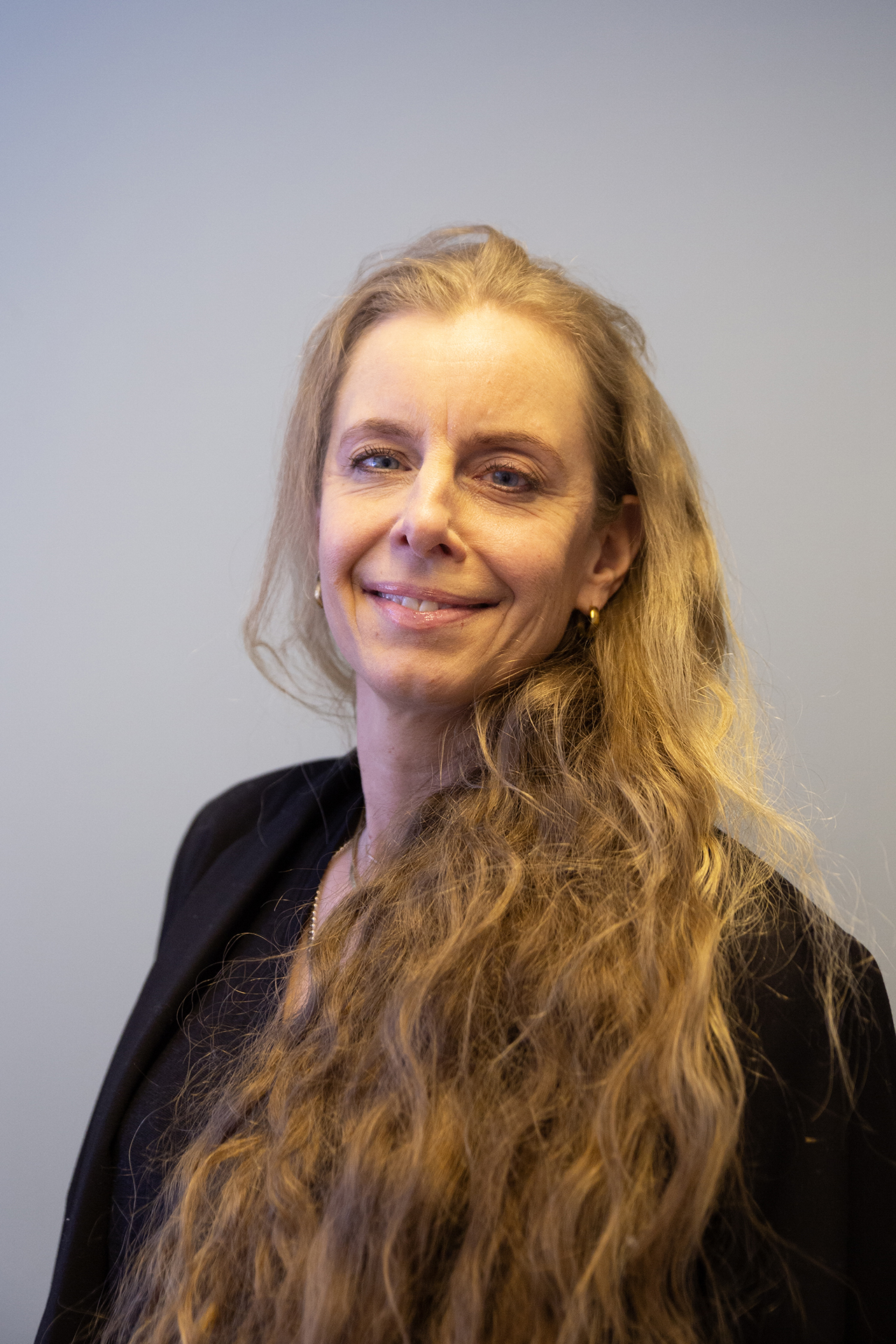 Portrettfoto av en smilende kvinne med langt hår