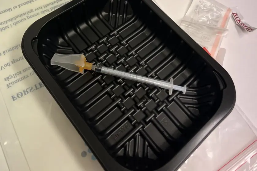 En sprøyte som ligger i en sort eske.