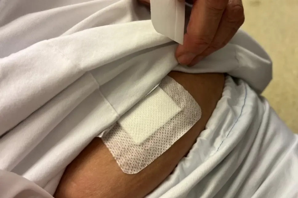 En person som setter på et plaster på magen