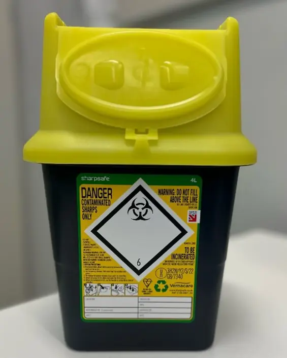 En gul kanylebøtte med en etikett