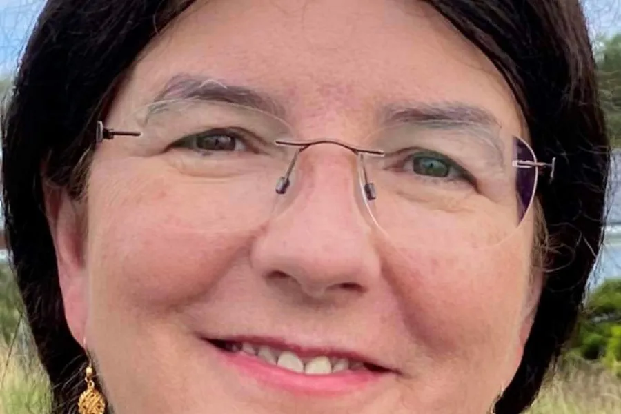 En kvinne med briller som smiler