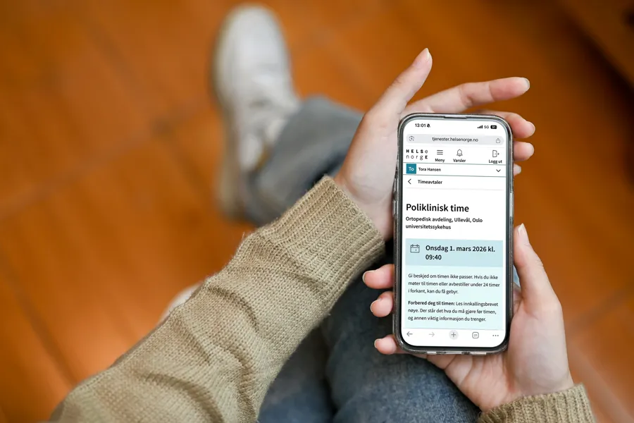 Nærbilde av to hender som holder en mobiltelefon