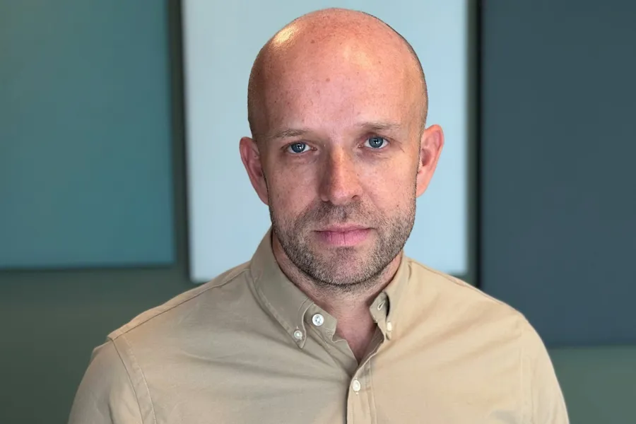 En skallet mann i solbrun skjorte