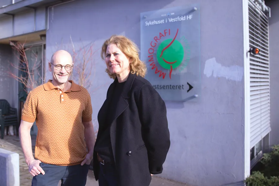 En mann og kvinne som står ved siden av et skilt