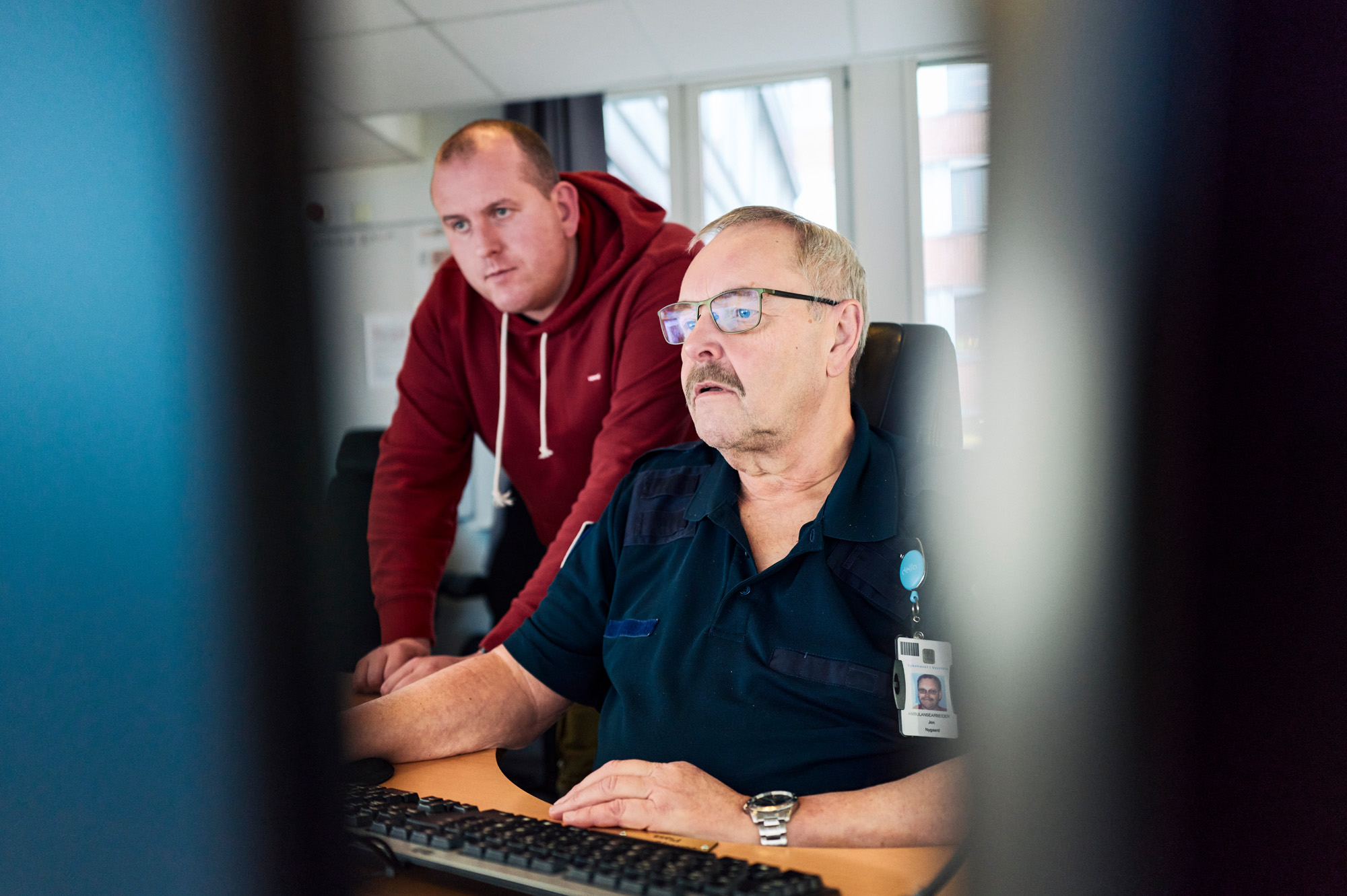 To personer ved et skrivebord med PC-skjermer