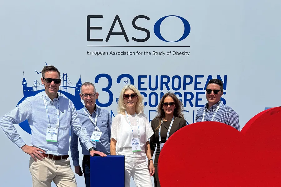 Fem personer med konferansebadger står foran en stor EASO‑bakvegg under den europeiske fedmekongressen. Bakgrunnen viser grafiske elementer og kongresslogo.