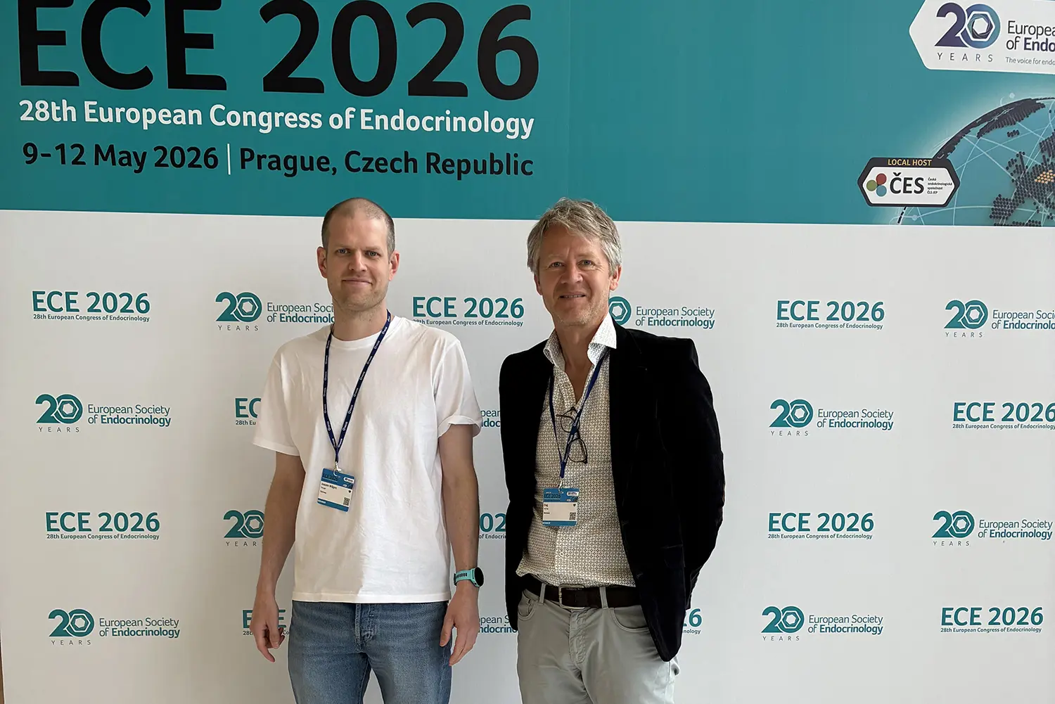 To personer står foran en bakvegg for ECE 2026, den europeiske endokrinologikongressen i Praha. Bakgrunnen viser logoer, dato og grafiske elementer.