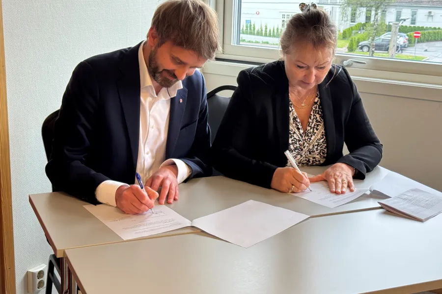 En mann og en kvinne som skriver på papir