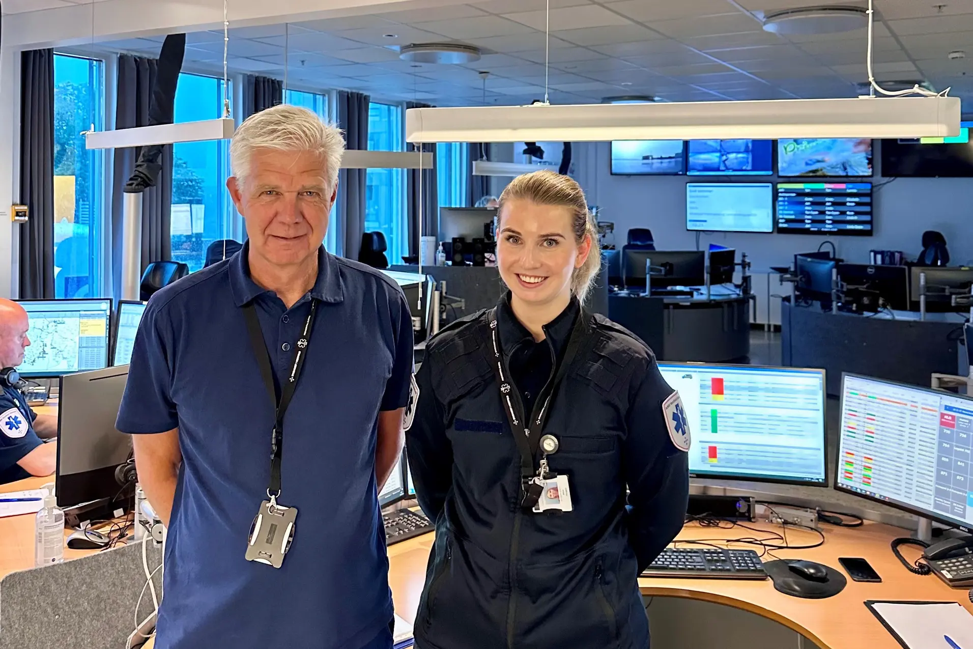 En mann og en kvinne som står foran datamaskiner