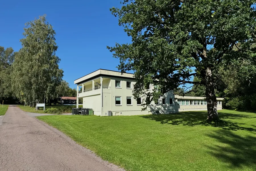 En bygning med trær og gress rundt