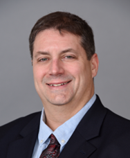 En mann i dress som smiler