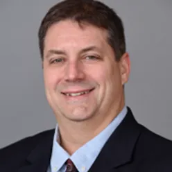 En mann i dress som smiler