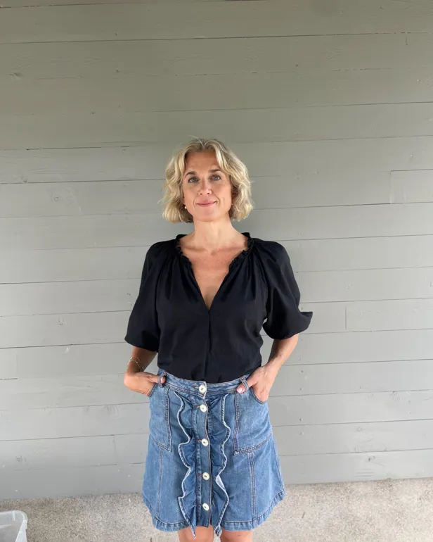 En person som står foran en hvit vegg