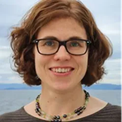 En kvinne med briller som smiler