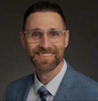 En mann med briller og dress