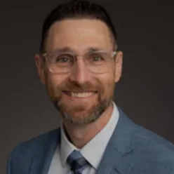 En mann med briller og dress