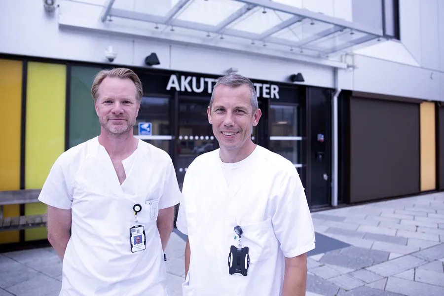 To menn som står foran en bygning