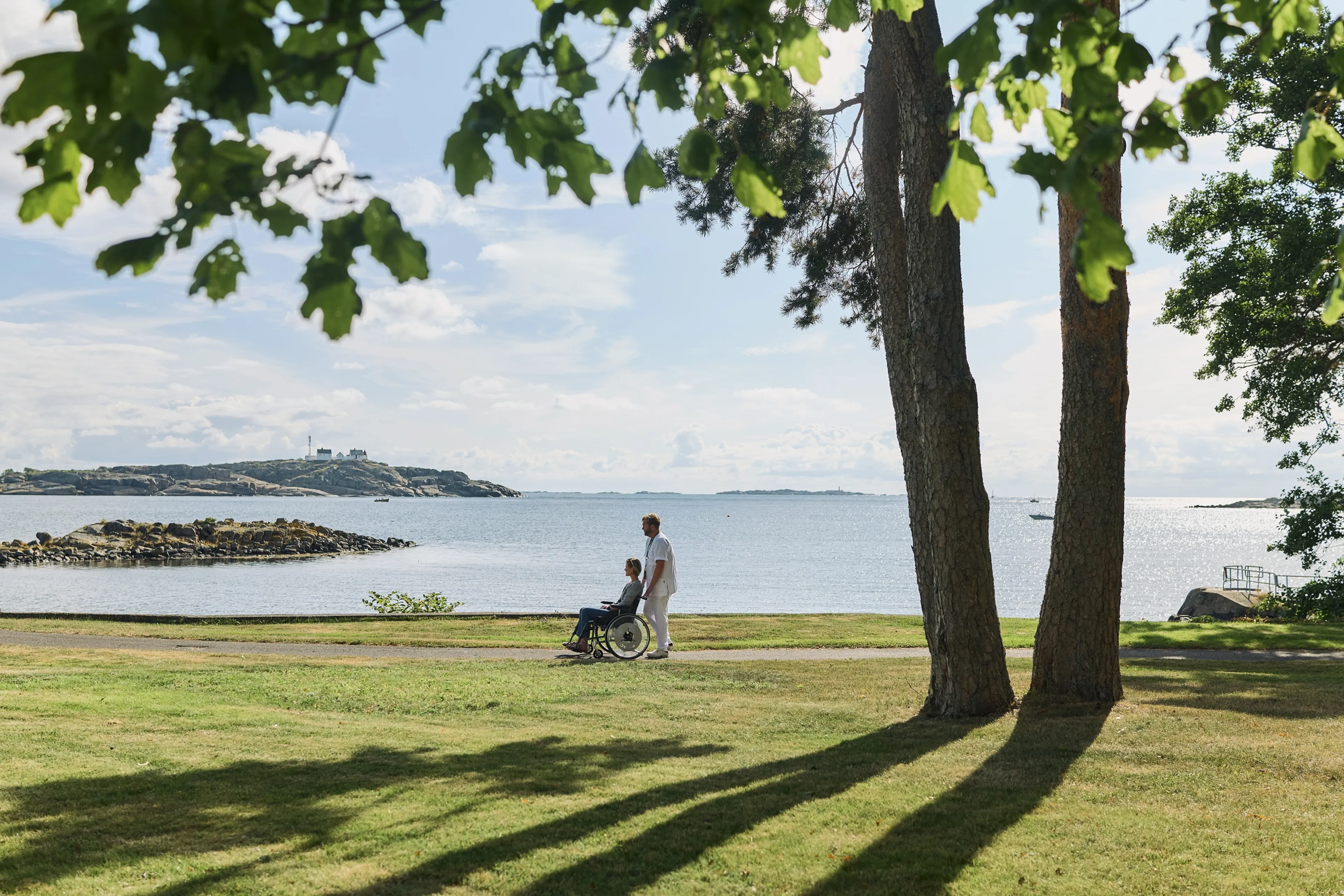En person og et barn som går på en sti ved et vann