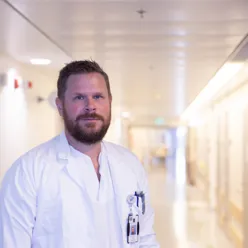 Mann med skjegg som smiler i kamera