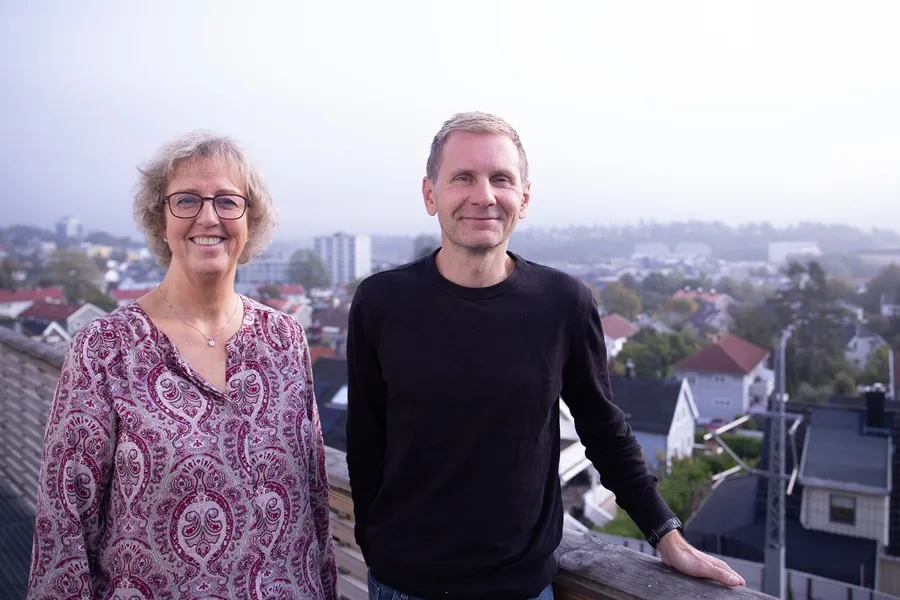 En mann og kvinne som står på en balkong med utsikt over en by