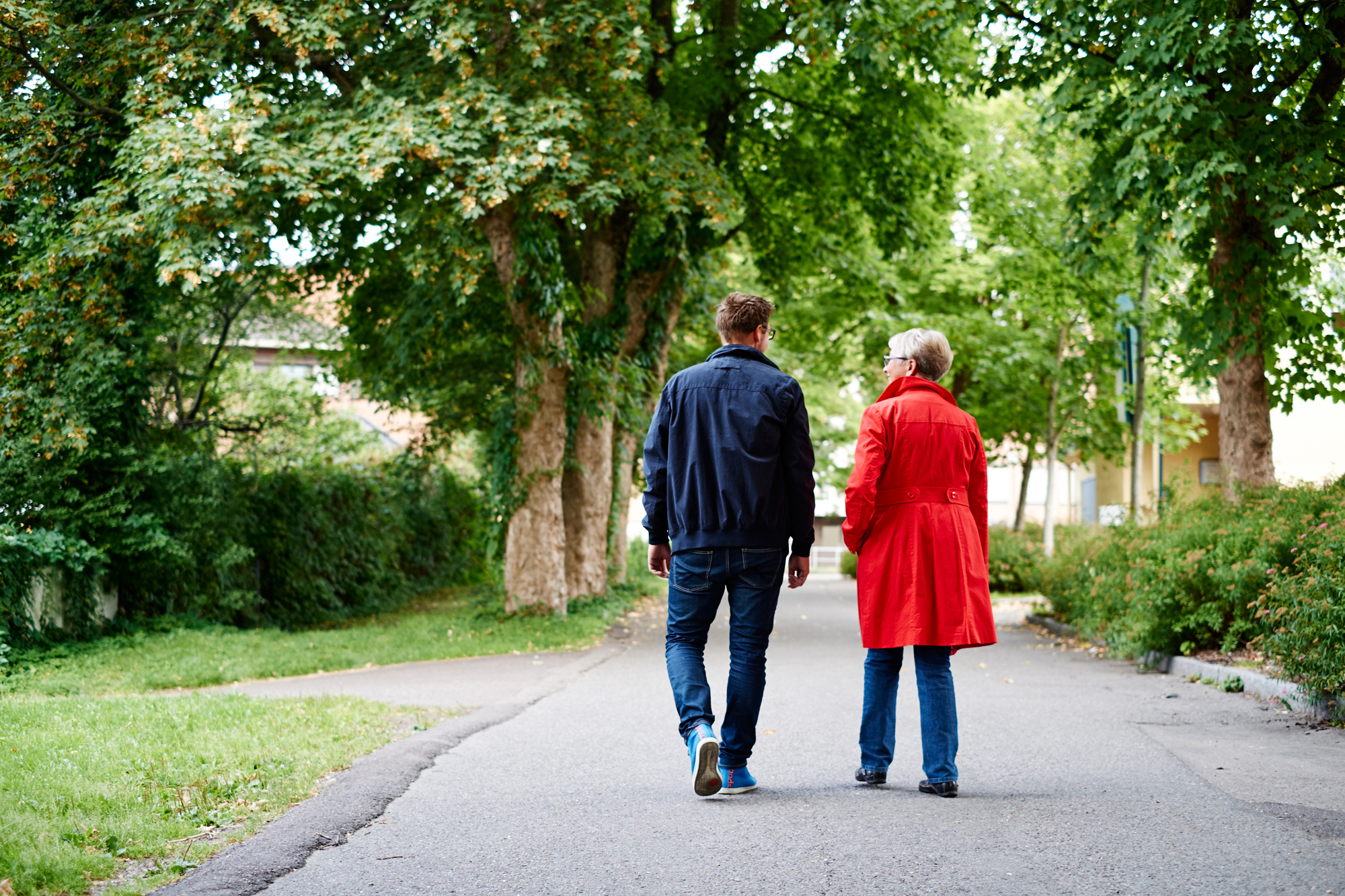 En mann og kvinne som går nedover en sti i en park