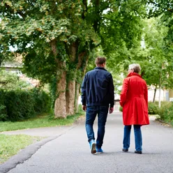 A man and woman walking down a path in a park
