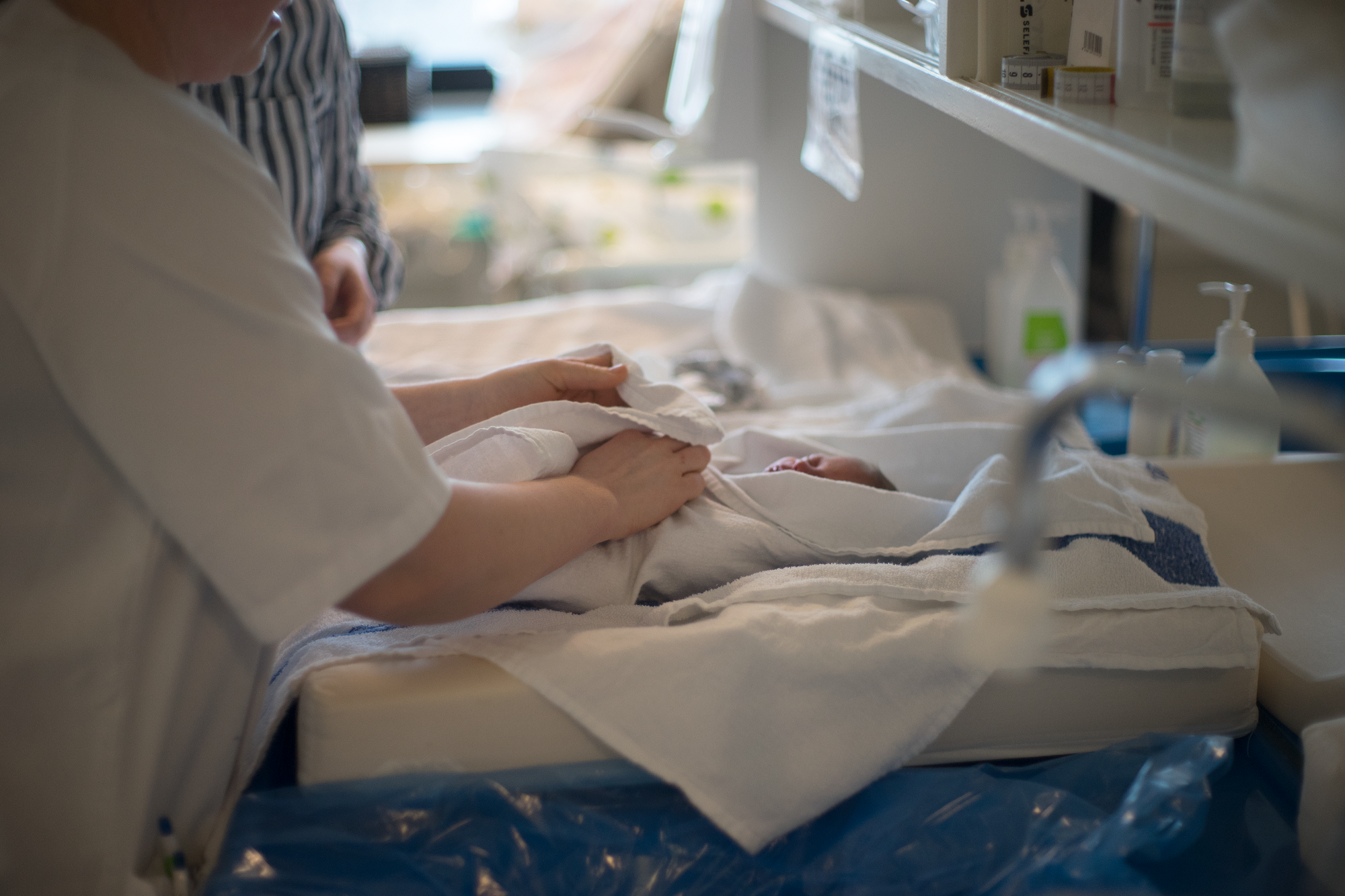 Bilde av baby som pakkes inn i håndkle