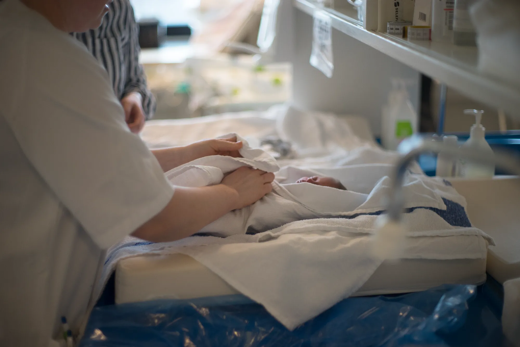 Bilde av baby som pakkes inn i håndkle