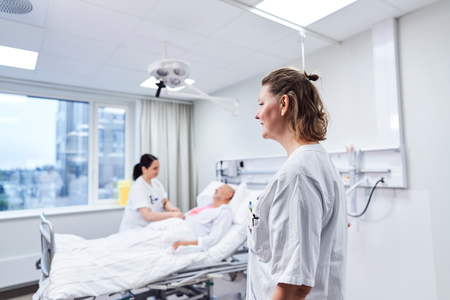 To sykepleiere ved en pasient i seng