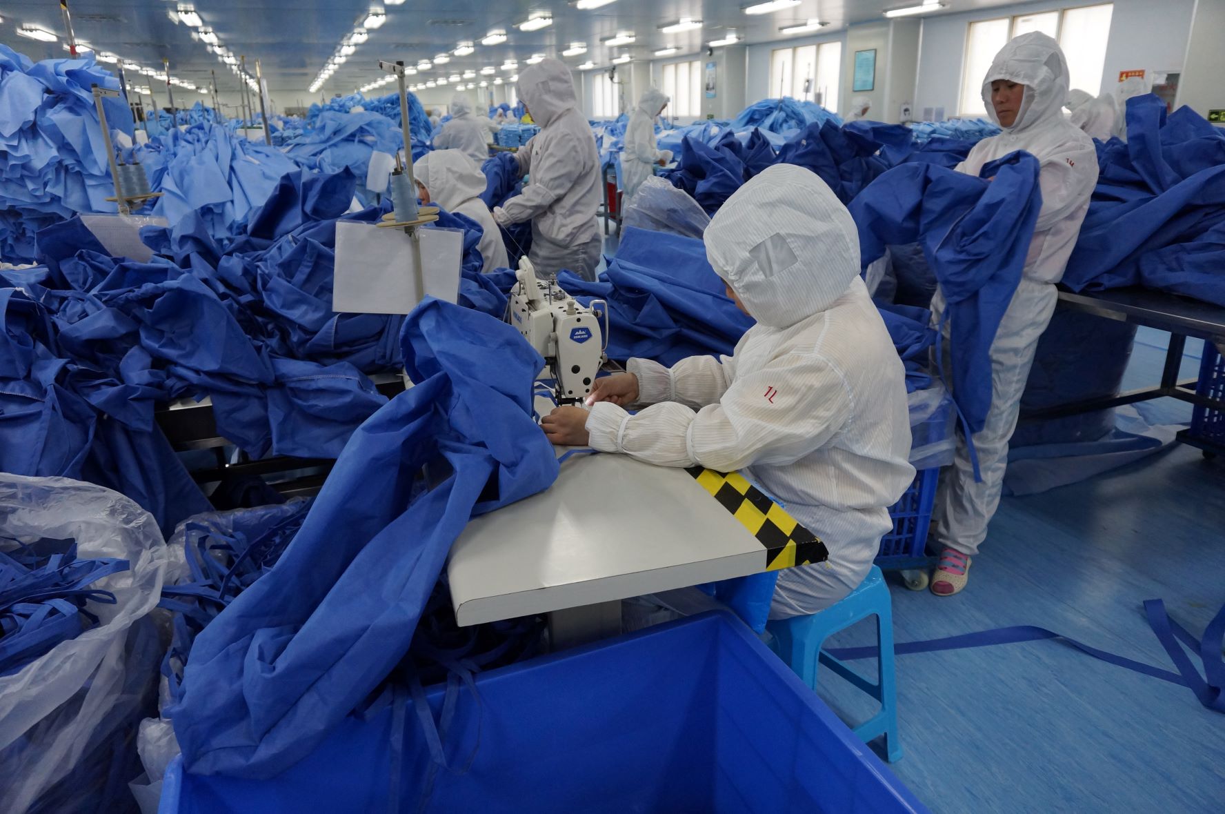 En gruppe mennesker i hvite frakker i et rom med blå laken