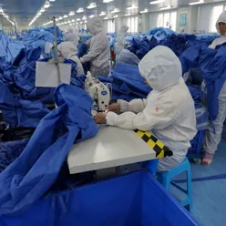 A group of people in white coats in a room with blue sheets