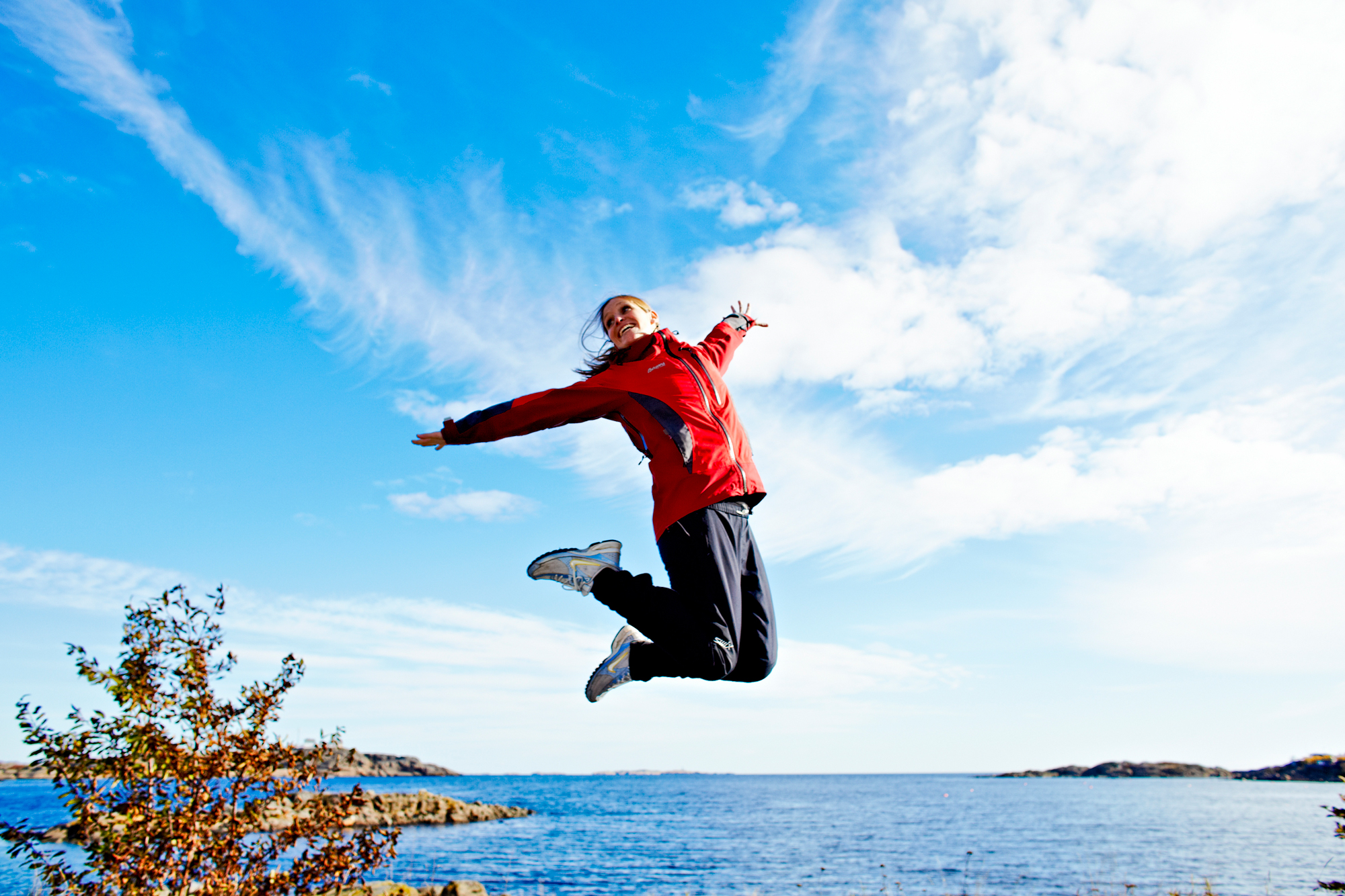 Kvinne som hopper opp i luften