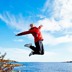 Kvinne som hopper opp i luften