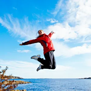 Kvinne som hopper opp i luften