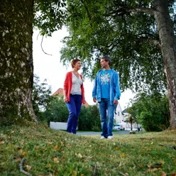 Kvinne og mann som går ute blant trær