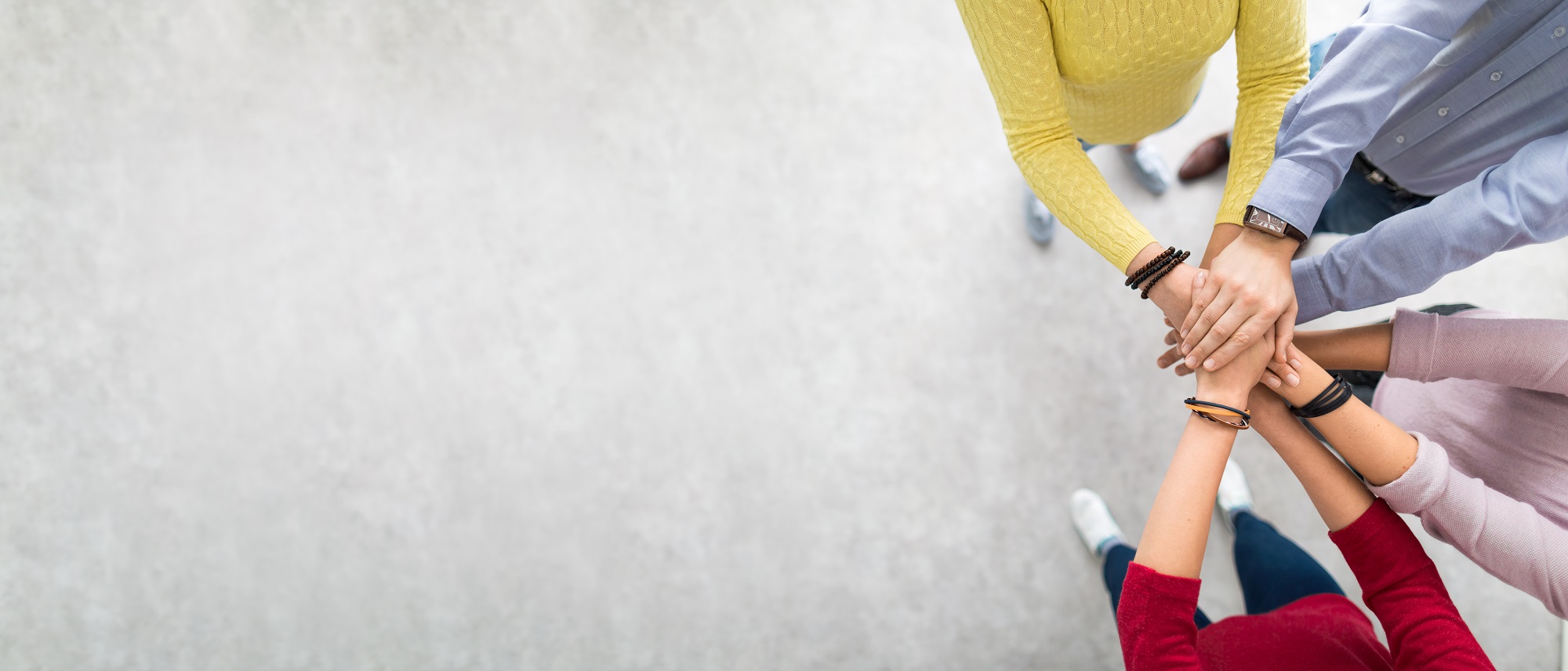 Nærbilde av hendene til fire personer som holdes på hverandres