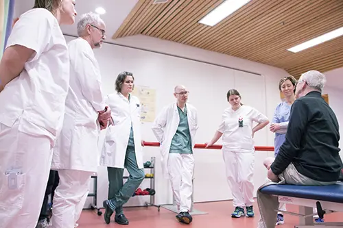 Fagfolk av flere yrkesgrupper lytter til pasienten.