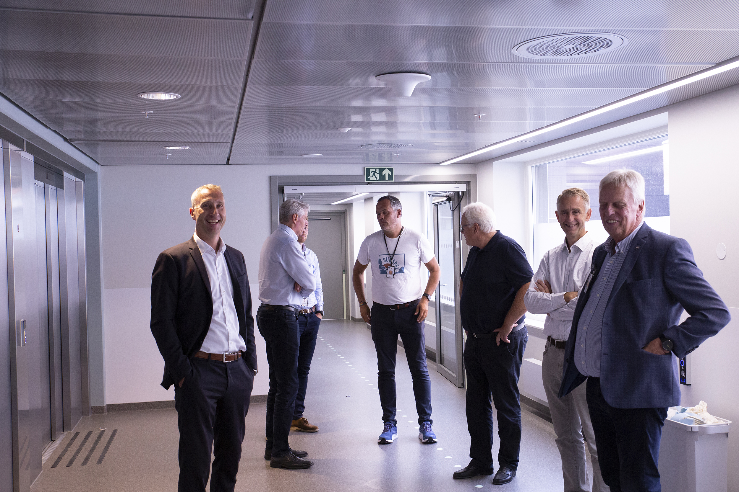 En gruppe mennesker som står i gangen