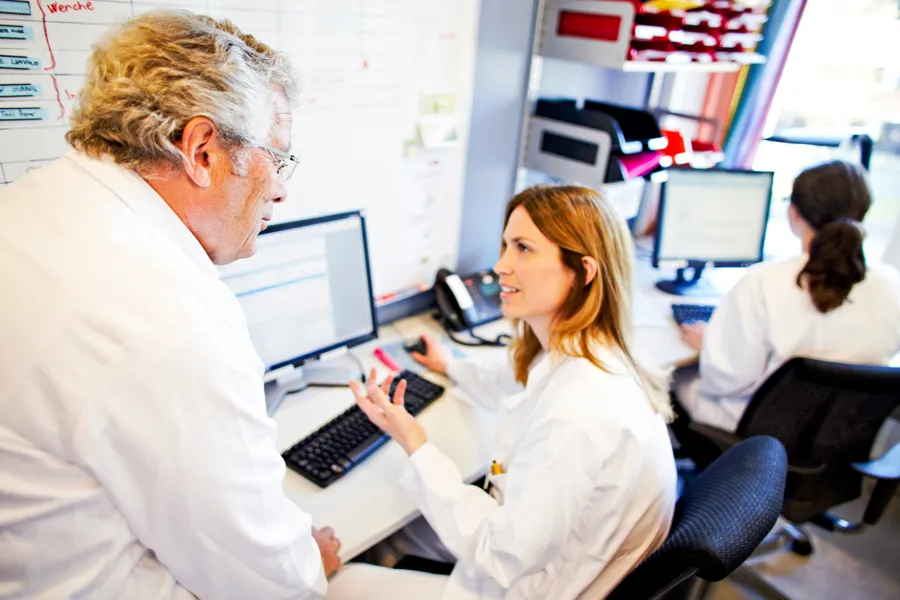 En mann som viser en kvinne noe på datamaskinen