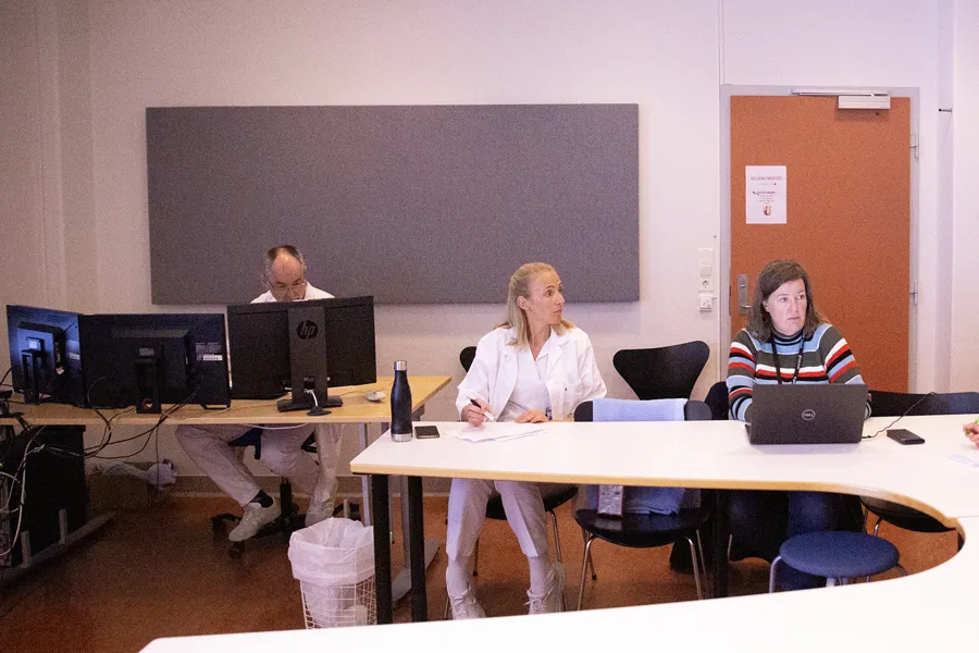 En gruppe kvinner som sitter ved et bord med datamaskiner