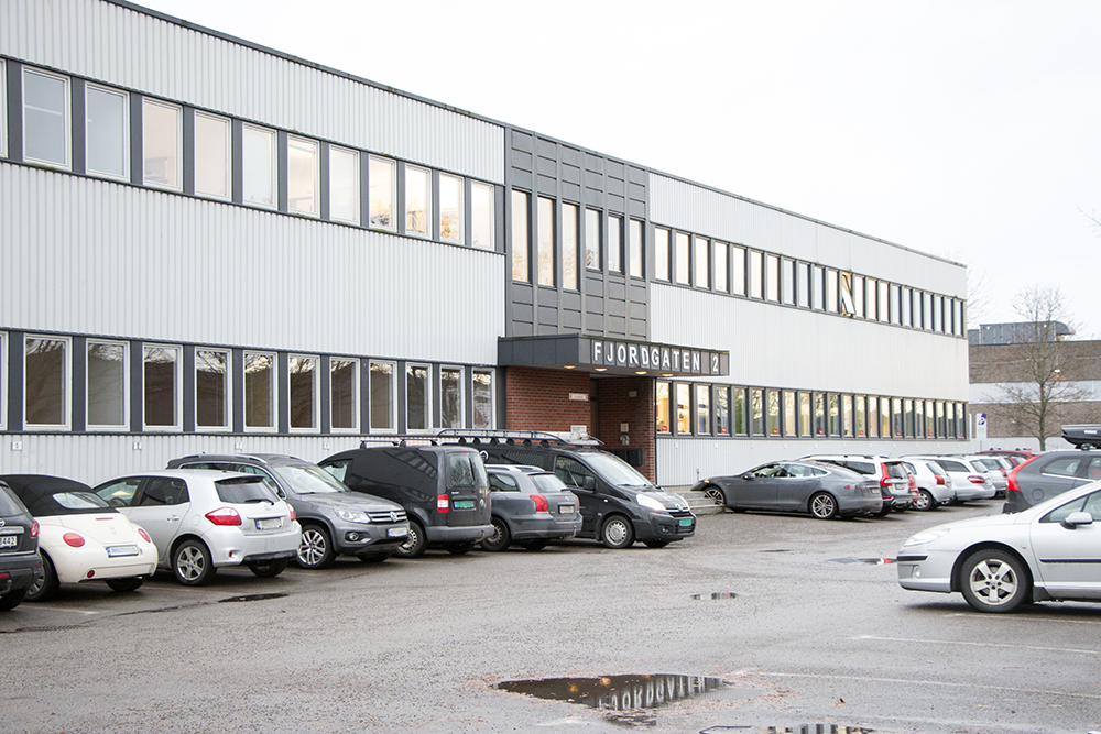 En parkeringsplass med biler foran en bygning