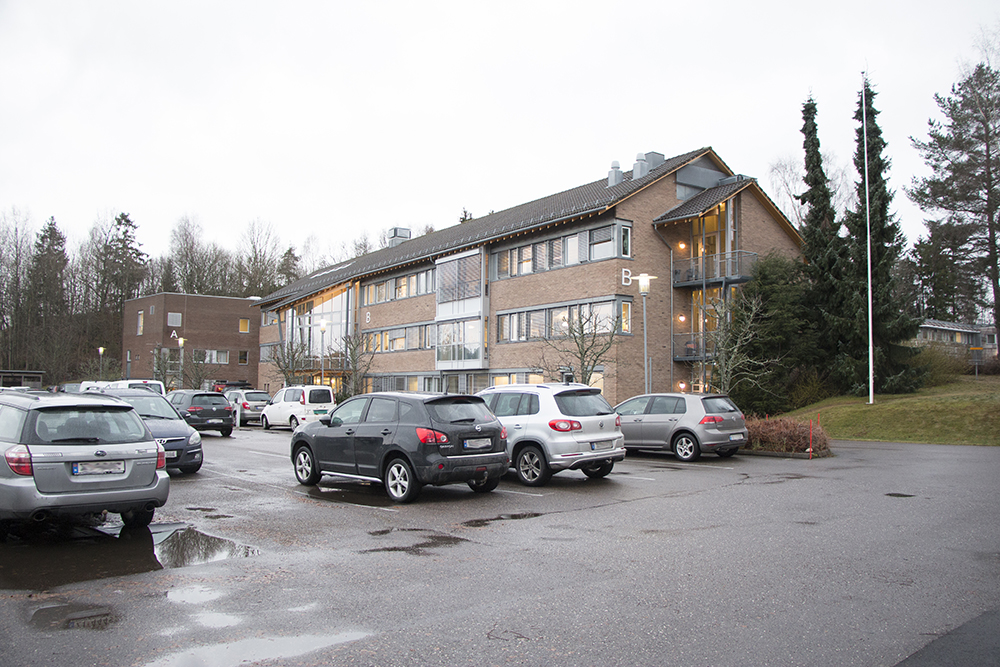 En parkeringsplass med biler og en bygning i bakgrunnen